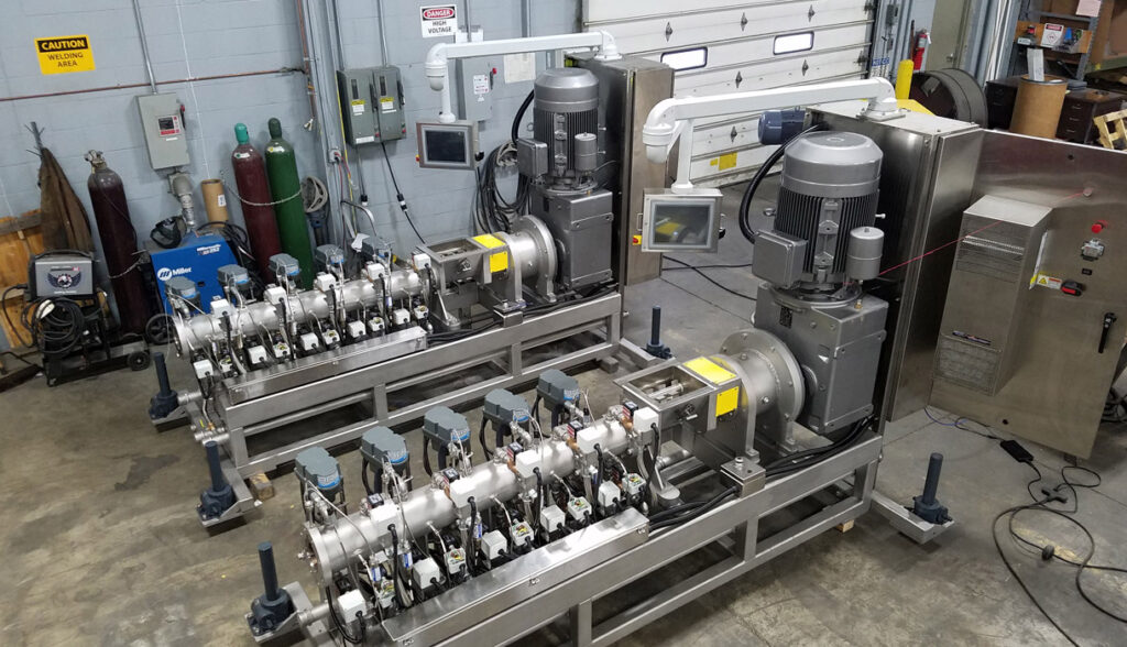 Two Bonnot custom cooking extruders in a warehouse.