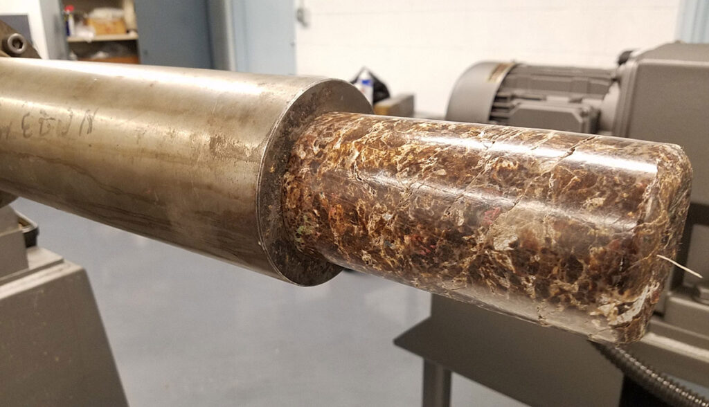 Fire log being extruded from a Bonnot extruder machine.