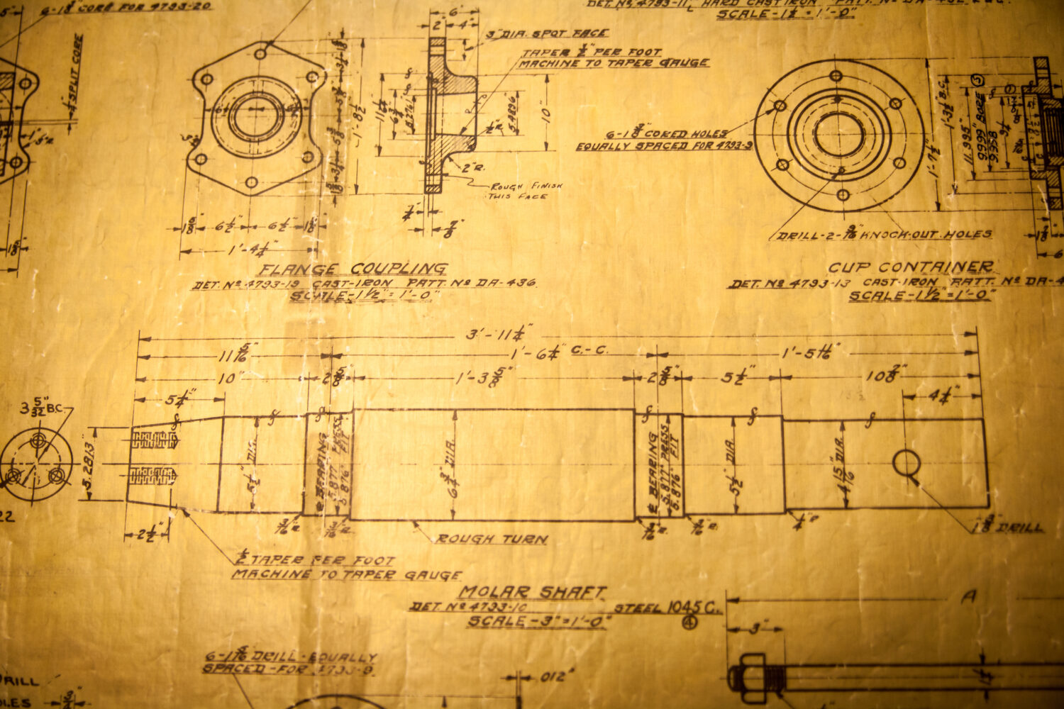 Detailed mechanical blueprint showing technical drawings and labeled measurements for parts such as a flange coupling, cup container, and molar shaft on yellowed paper.